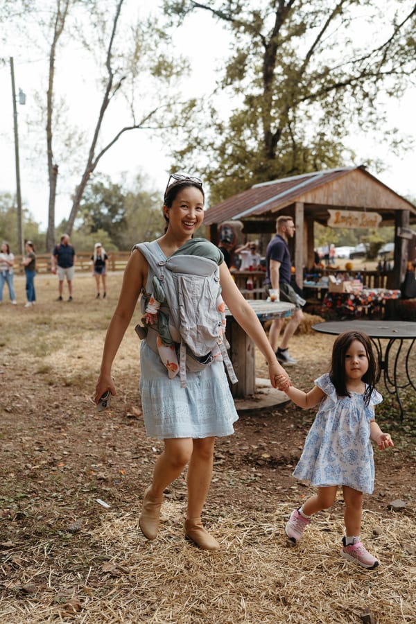 Mom wearing her baby, walking the grounds with her daughter