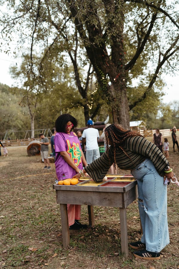 Guests playing a pumpkin game at a wooden table