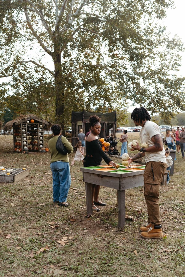 Guests playing a pumpkin game at a wooden table