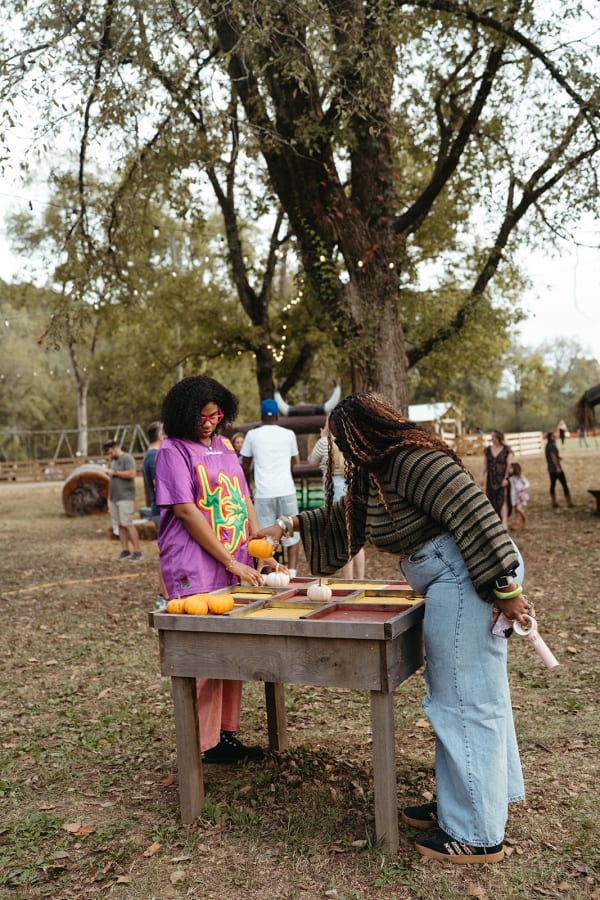 Guests playing a pumpkin game at a wooden table