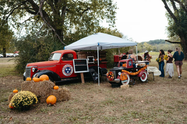 Vintage red truck and canopy with pumpkins and mums