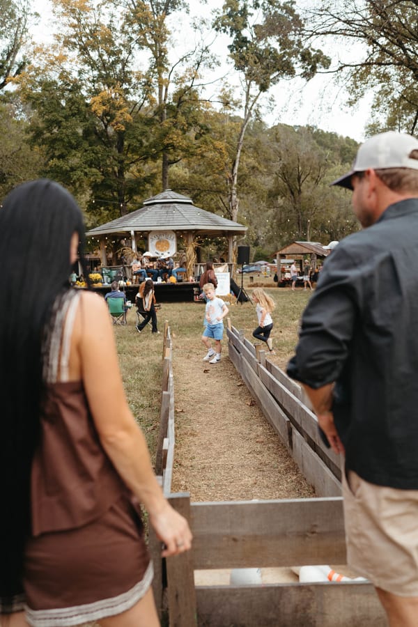 Families at the wooden play trough near the gazebo