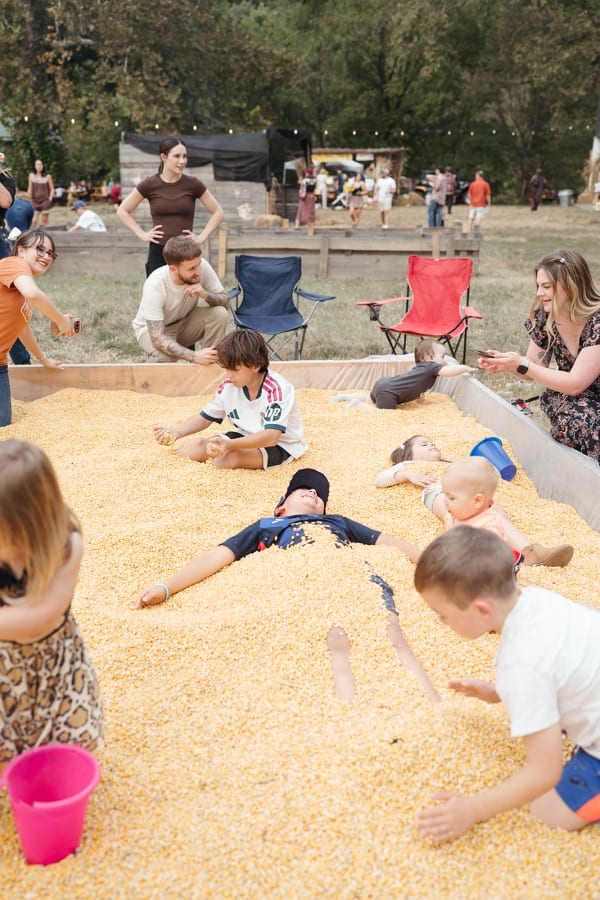 Kids playing and digging together in the corn pit