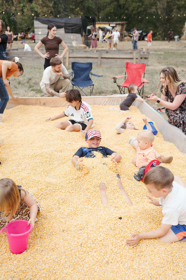 Kids playing and digging together in the corn pit