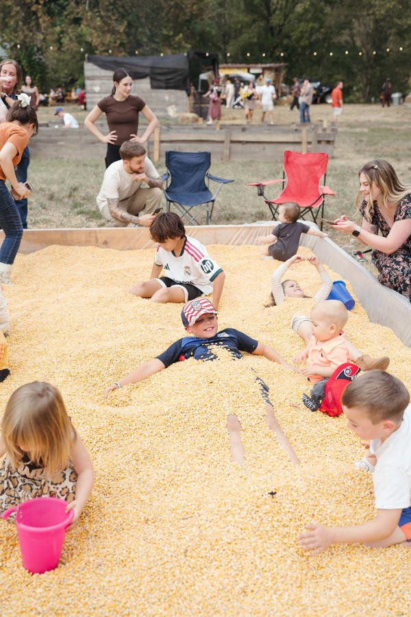 Kids playing and digging together in the corn pit