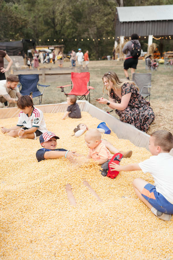 Kids playing and digging together in the corn pit