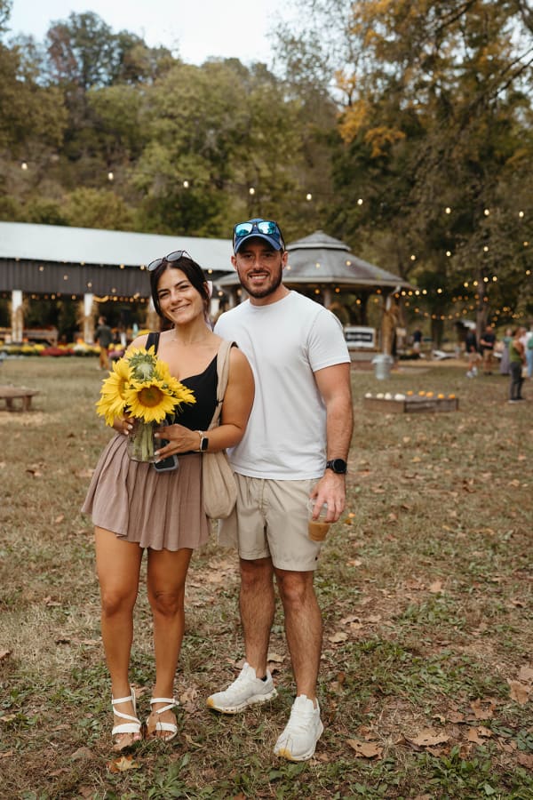 Couple posing with a sunflower bouquet