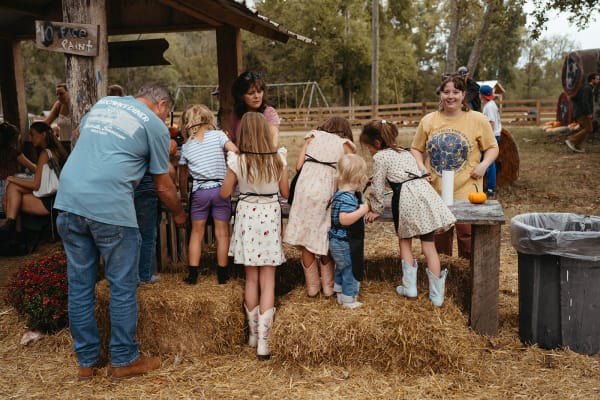 Families gathered at a hay-lined pen