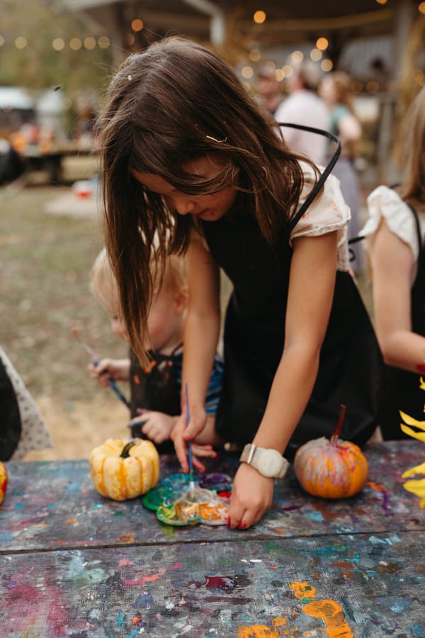 Girl painting a mini pumpkin