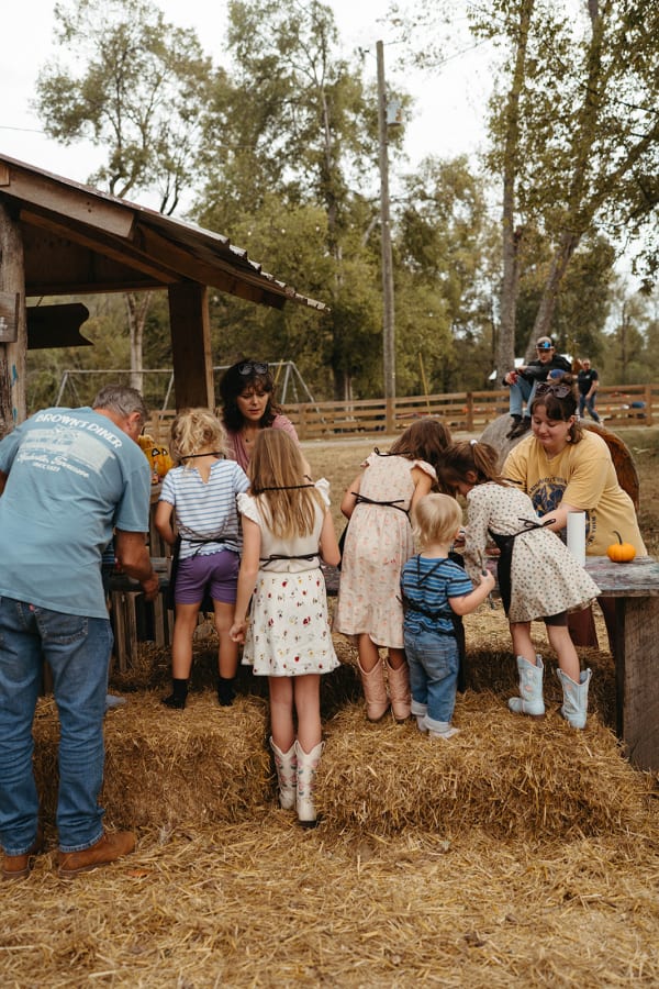 Families gathered at a hay-lined pen