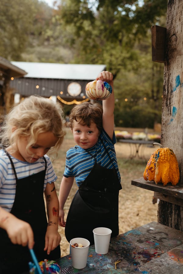 Kids in aprons showing off their painted pumpkins