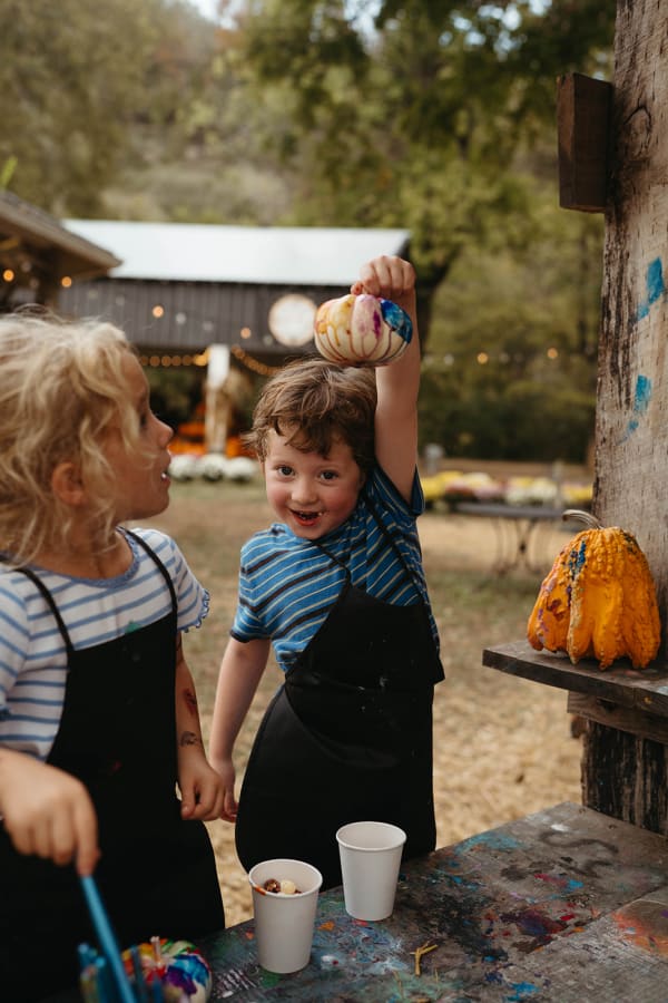 Kids in aprons showing off their painted pumpkins