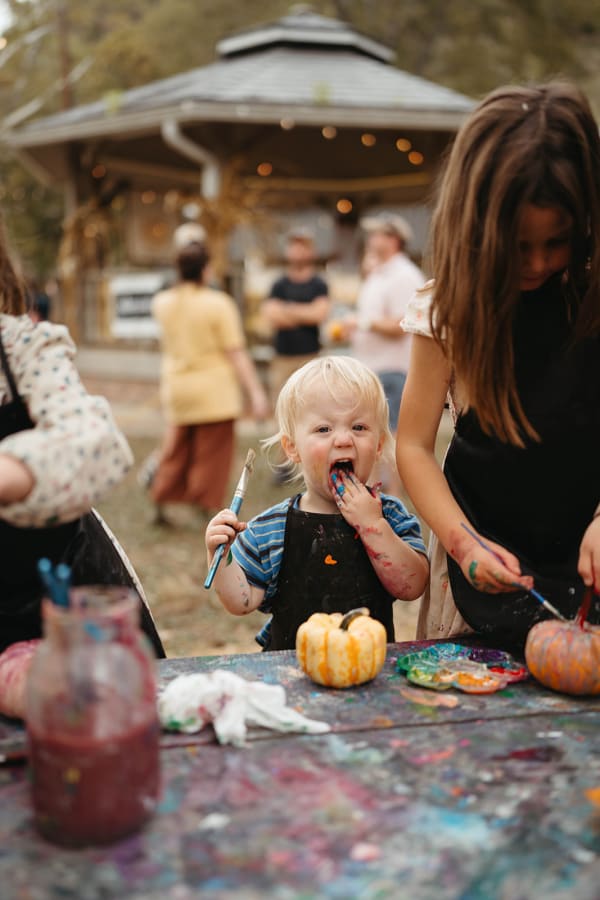 Kids painting mini pumpkins at the paint table