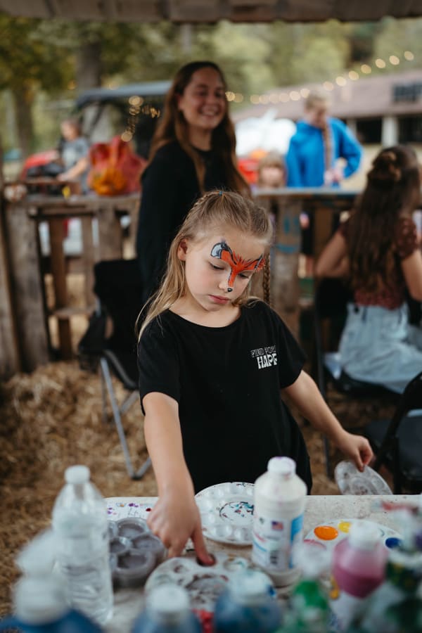 Girl with a butterfly face paint at the face-painting table
