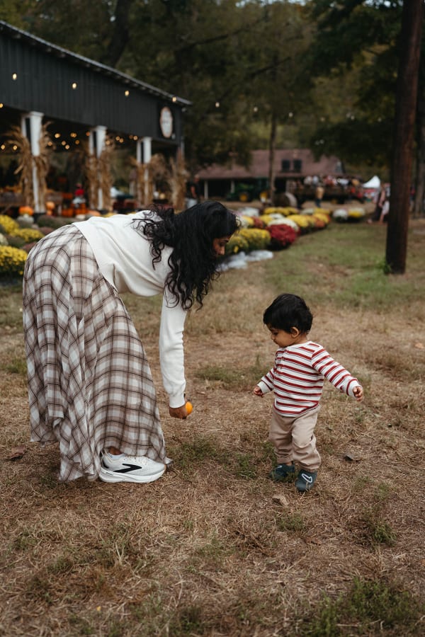 Mom and toddler walking among the mums