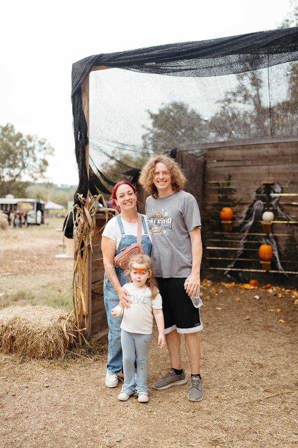 Family posing in the rustic wooden play area