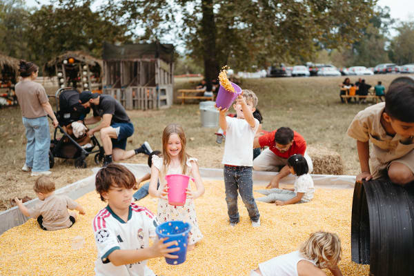 Kids digging with buckets in the corn pit