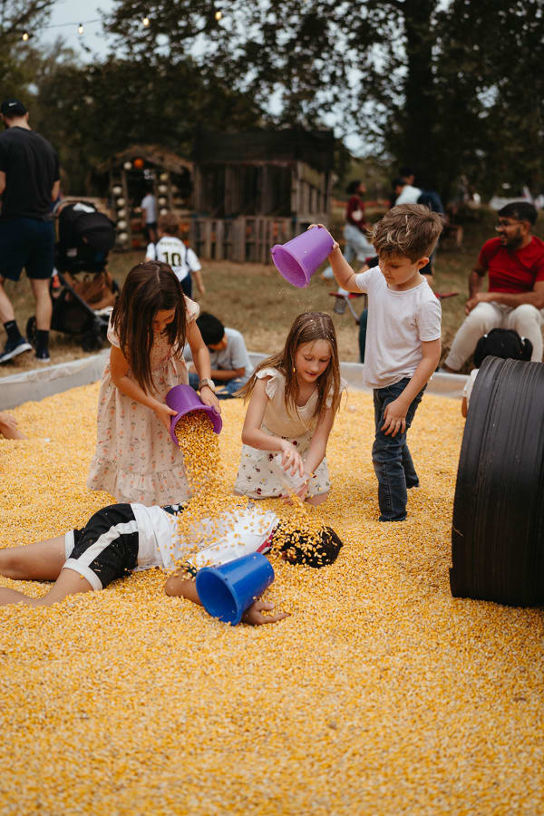 Kids digging with buckets in the corn pit