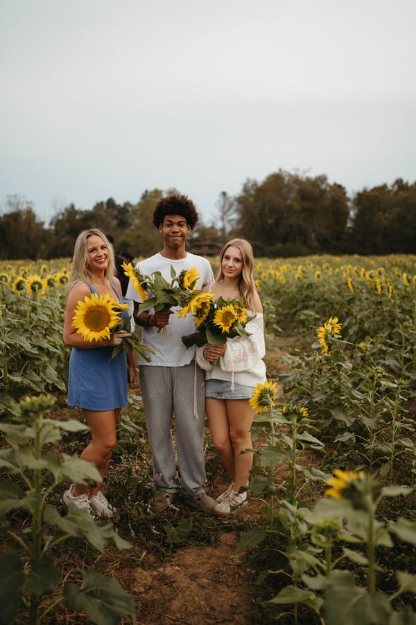 Friends holding sunflowers in the sunflower field