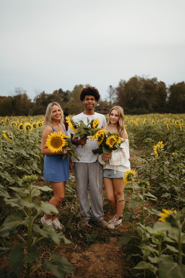 Friends holding sunflowers in the sunflower field