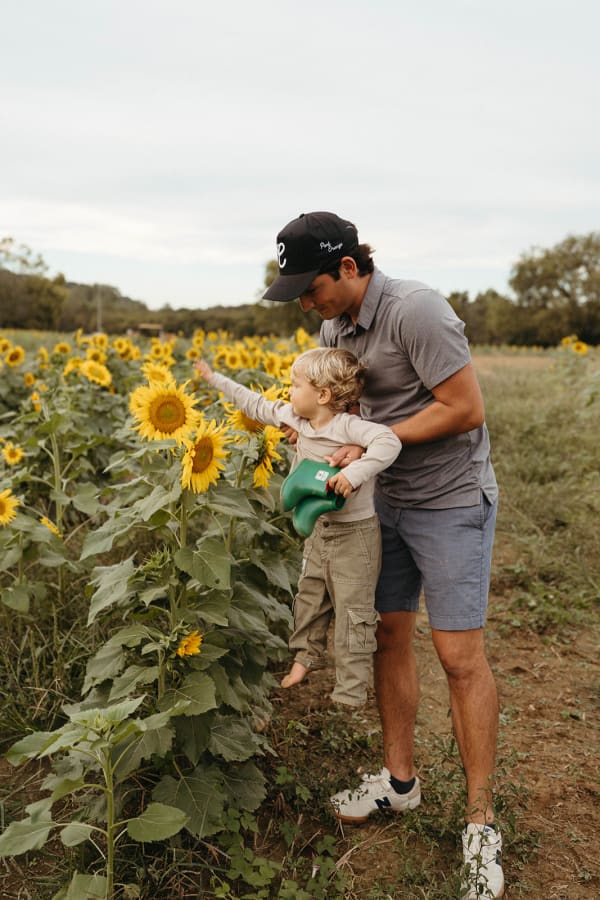 Dad and son reaching for a sunflower