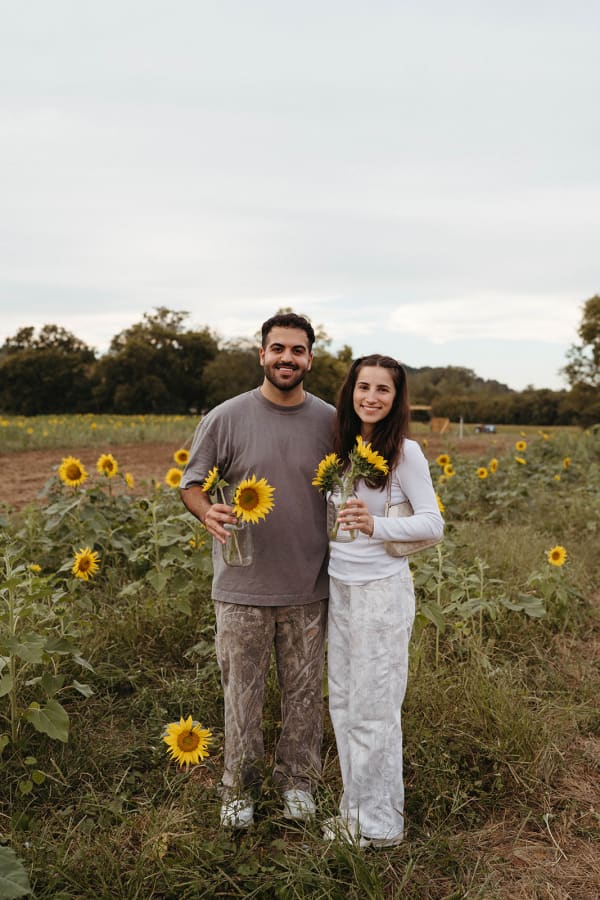 Couple holding sunflowers in the field