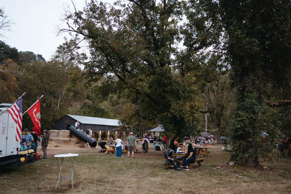 Families gathered under the trees by the flags