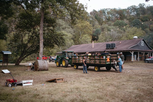 Tractor-pulled hayride wagon by the barn