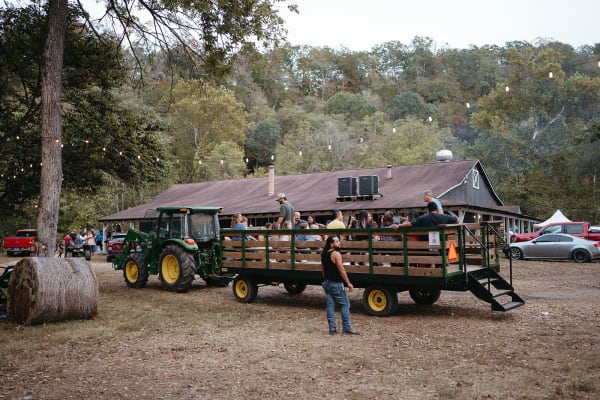 Tractor-pulled hayride wagon by the barn