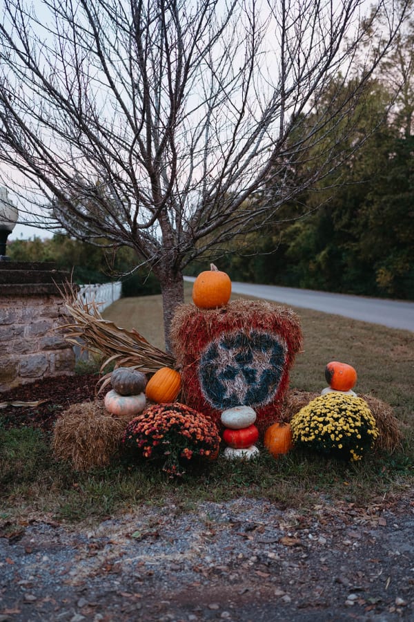 Painted tri-star display with pumpkins and mums at the entrance