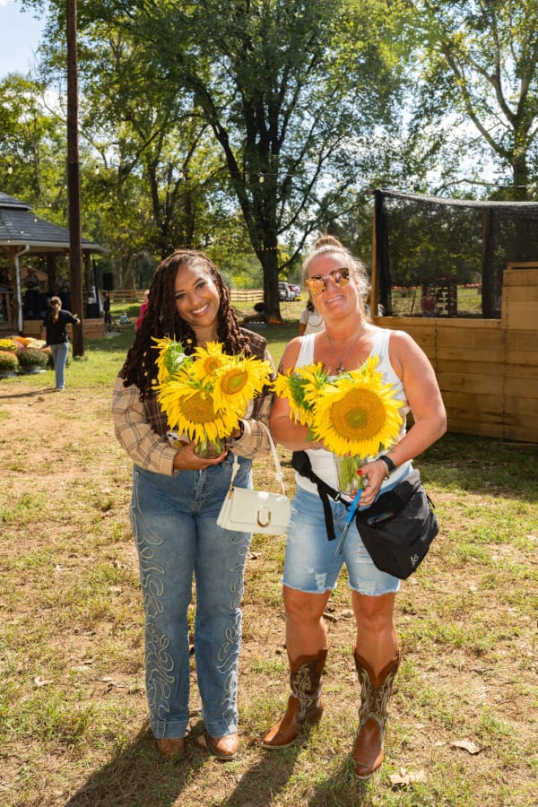 Friends holding sunflower bouquets