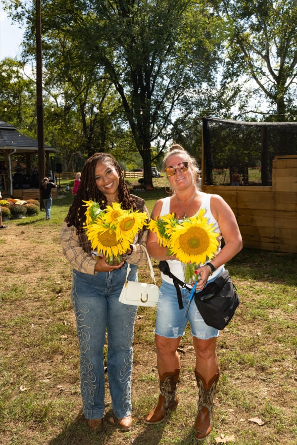 Friends holding sunflower bouquets