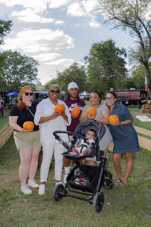 Family with pumpkins and a stroller