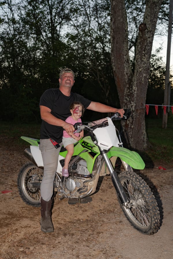 Dad and daughter on a green dirt bike