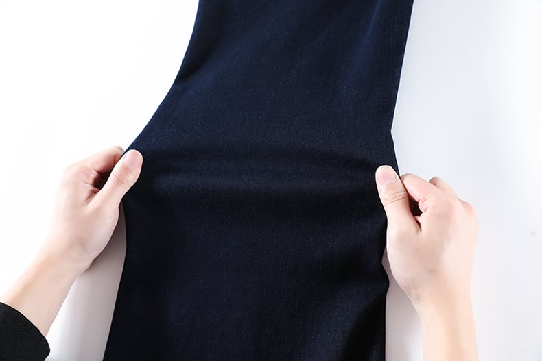 YEEYEEWang wide-leg jeans, Asian-fit cut, hands holding deep indigo denim at both sides to display the fabric's dense twill weave and soft feel.
