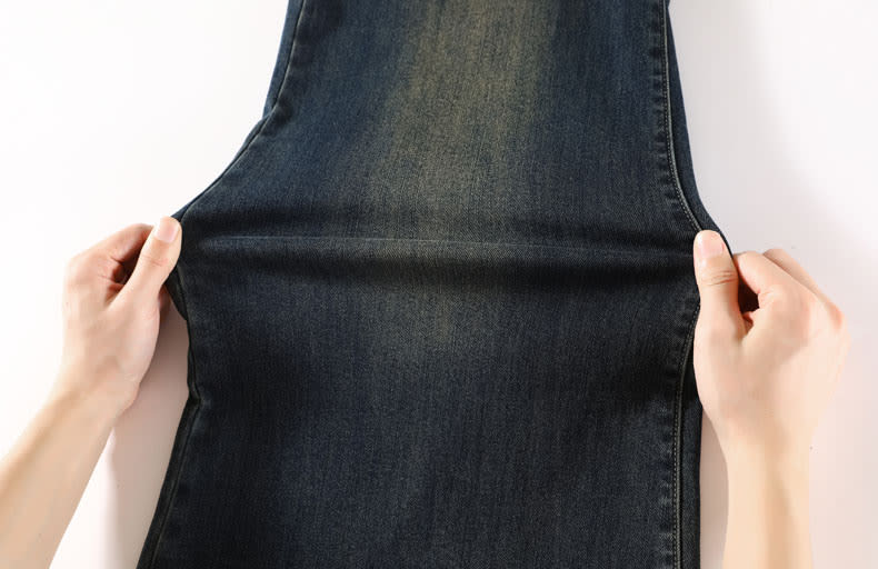 YEEYEEWang wide-leg jeans, Asian-fit cut, hands pulling the denim from both sides to show the fabric's flexible stretch.