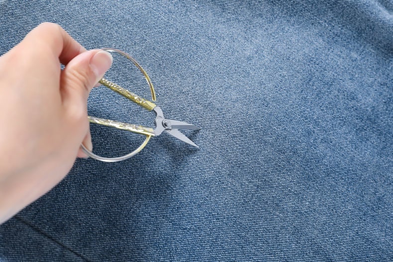 YEEYEEWang Denim Bermuda Shorts, Asian-fit cut, hand holding scissors against dense twill denim surface.