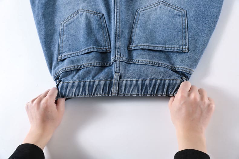 YEEYEEWang Denim Bermuda Shorts, Asian-fit cut, close-up of hands stretching the gathered elastic waistband.