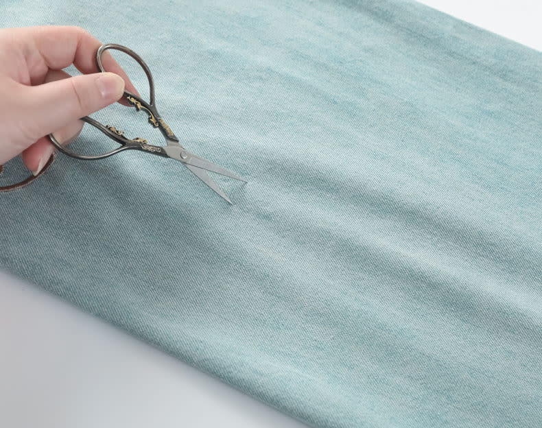 YEEYEEWang Wide-Leg Jeans, Asian-fit cut, close-up of dense twill denim shown with scissors resting on the fabric surface.