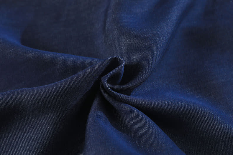YEEYEEWang Wide-Leg Jeans in Denim Blue, Asian-fit cut, fabric gathered in a soft swirl showing fine twill grain in macro detail.
