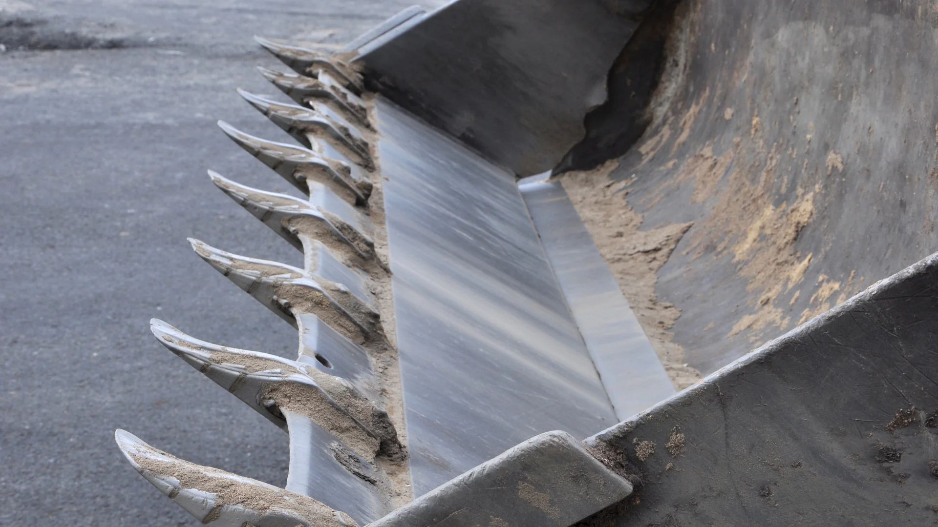 Excavator bucket teeth showing abrasive wear in an aggregates quarry
