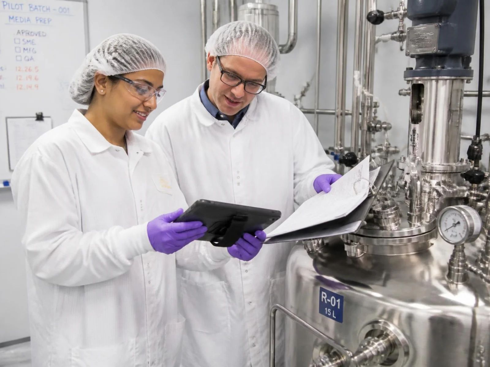 Pharmaceutical manufacturing team reviewing batch yield predictions and process insights