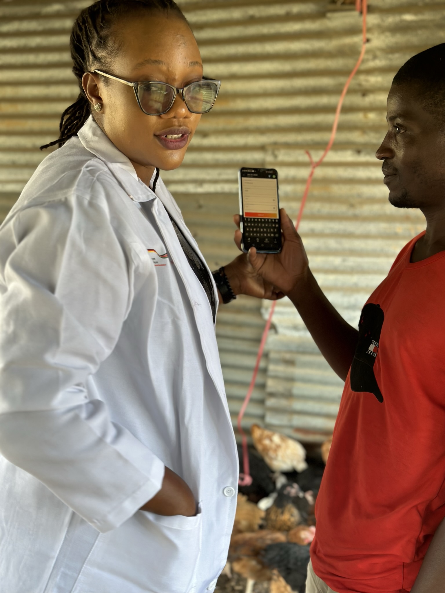 e-Poultry extension officer showing the app to a farmer