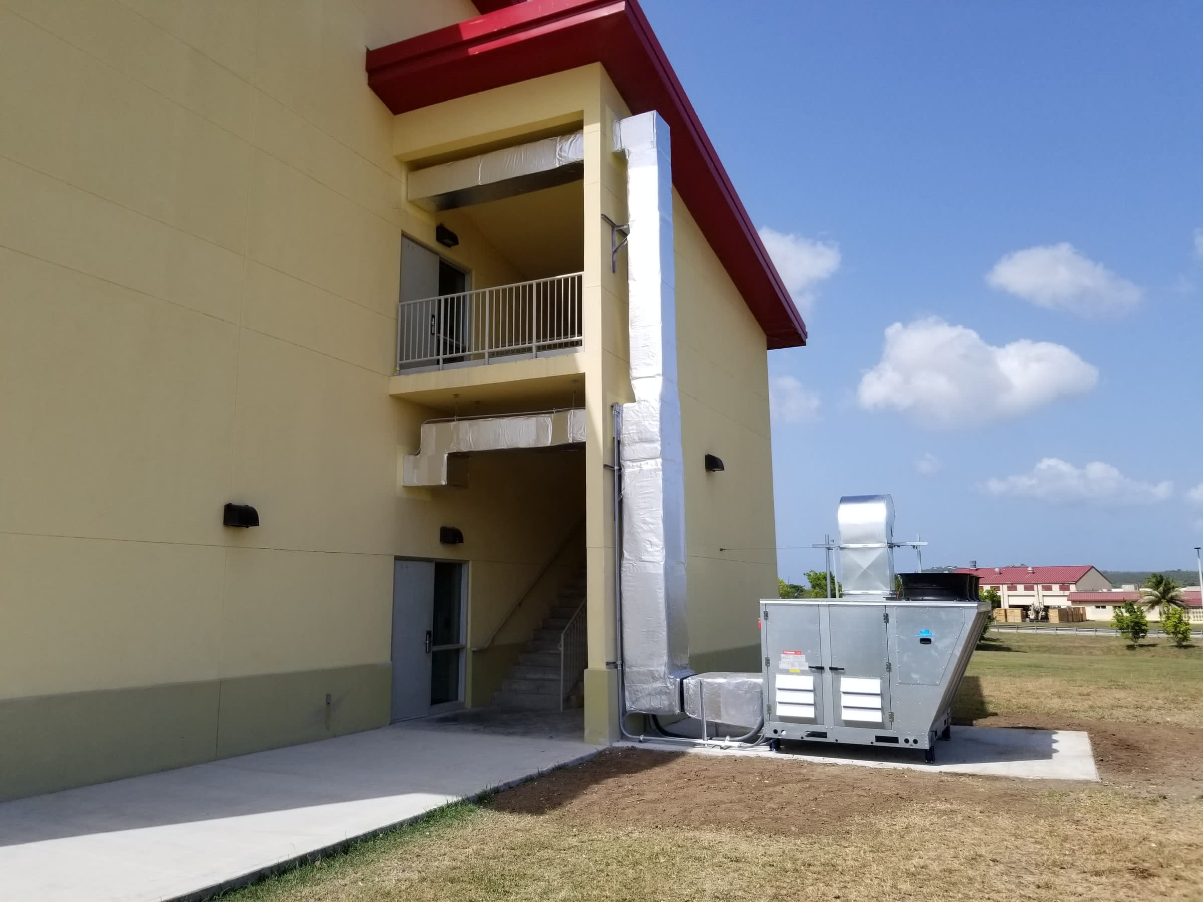 Unité de climatisation extérieure installée au pied d’un bâtiment