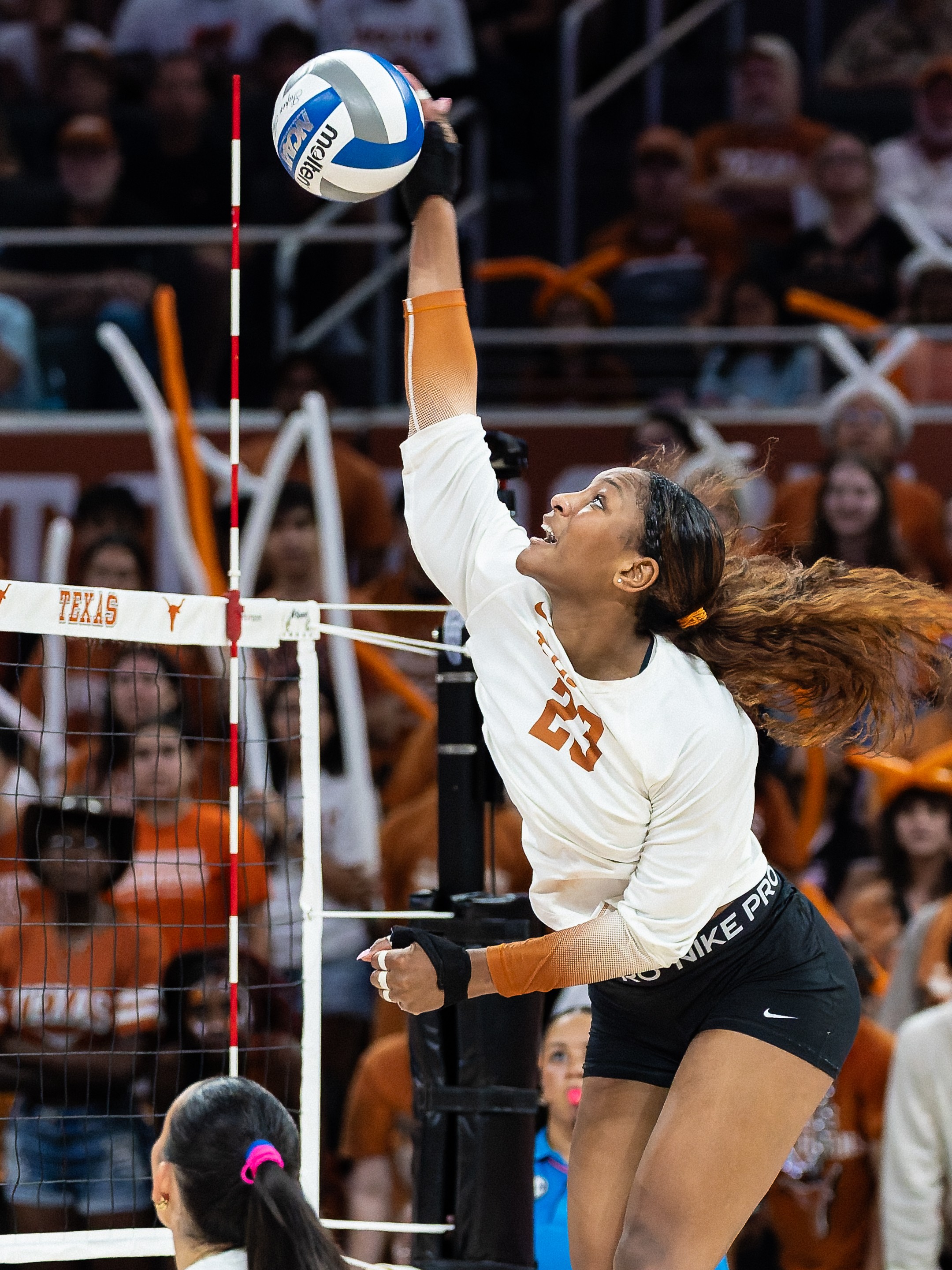 Texas volleyball player reaching to attack the ball against Wisconsin
