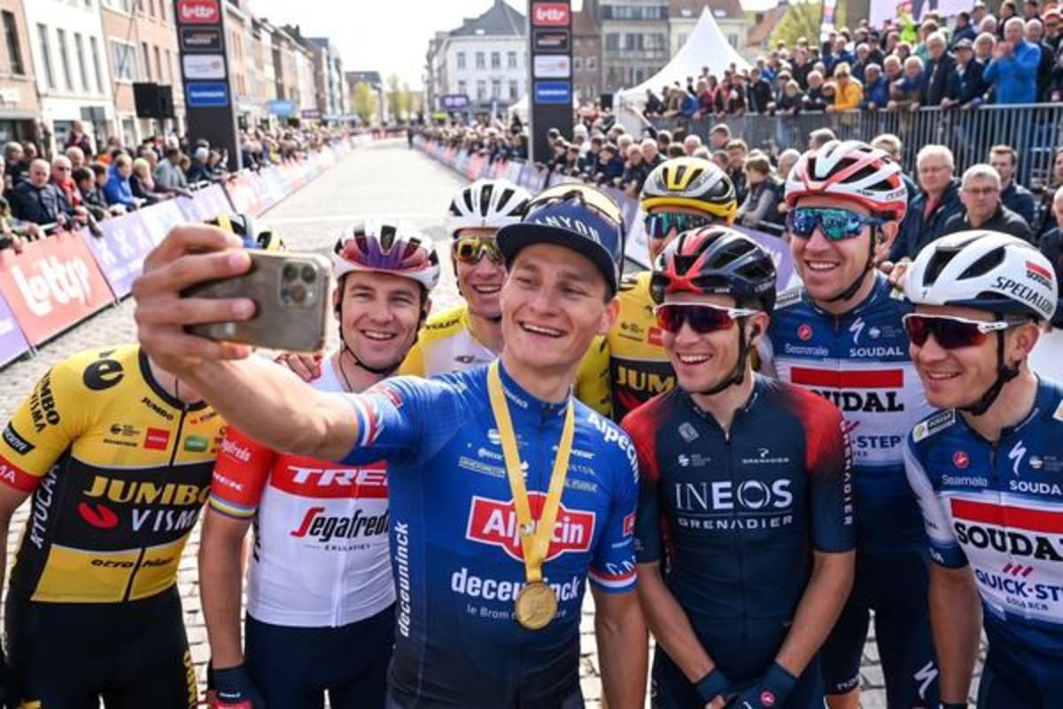 Ciclistas profesionales haciéndose una selfie con el público al fondo