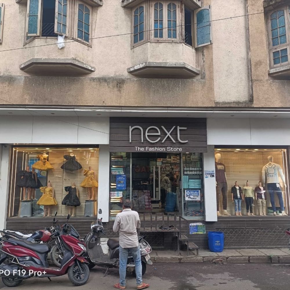 NEXT THE FASHION STORE logo