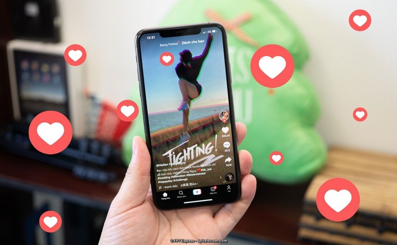 Một người đang cầm điện thoại với ứng dụng TikTok và biểu đồ tăng trưởng, biểu thị sự tăng trưởng hiệu quả khi tăng like TikTok