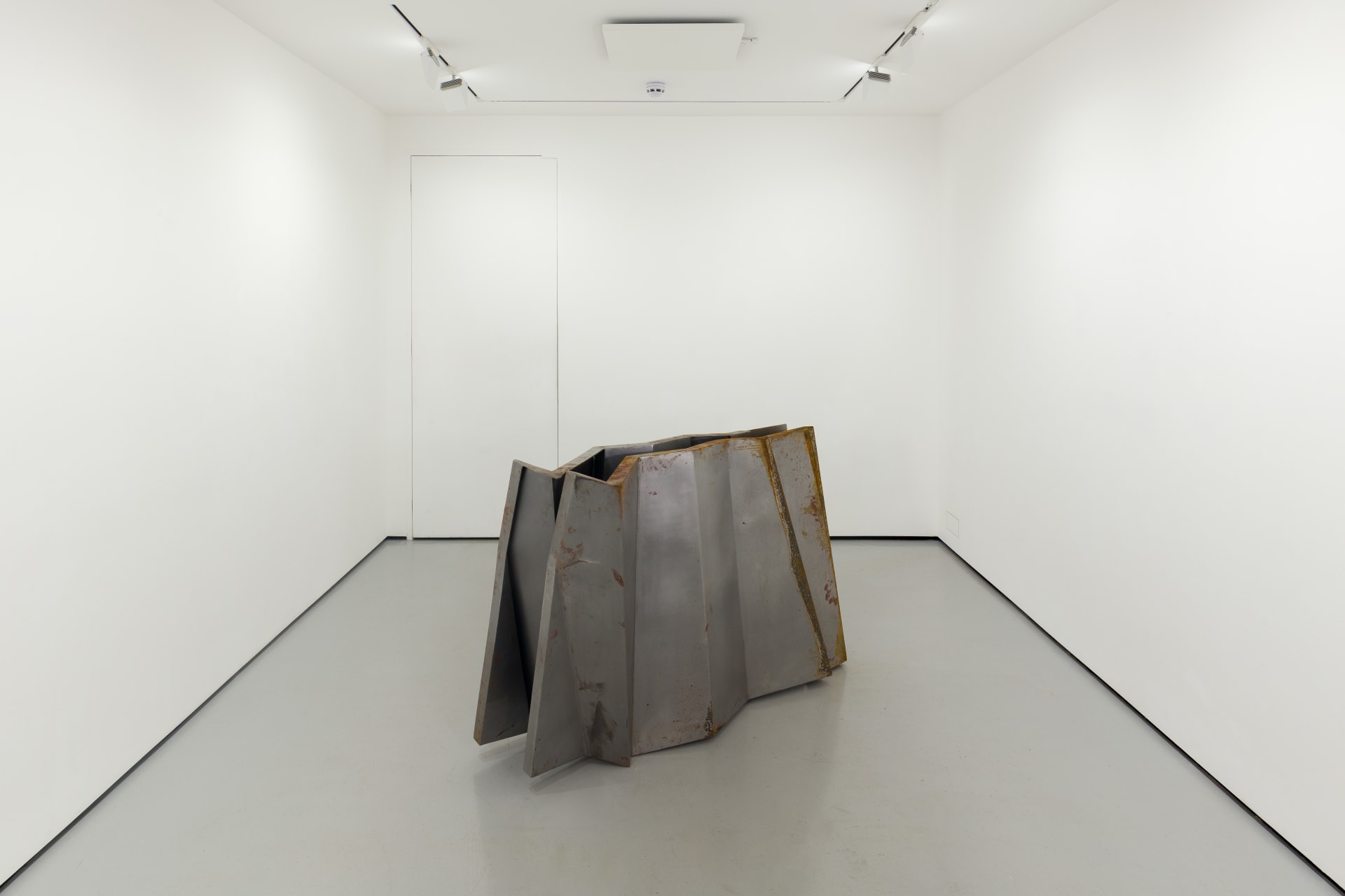 a steel sculpture by Hannah Perry with 2 walls in a ziggurat shape slightly apart from each other