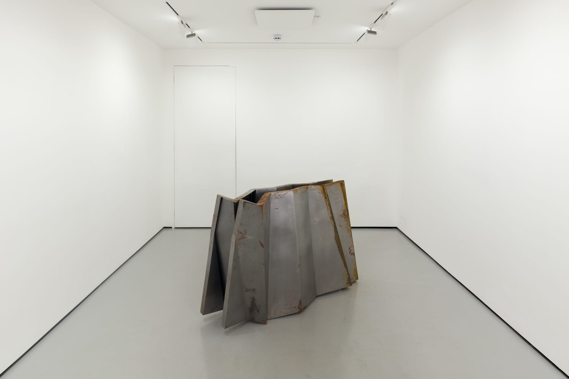 a steel sculpture by Hannah Perry with 2 walls in a ziggurat shape slightly apart from each other